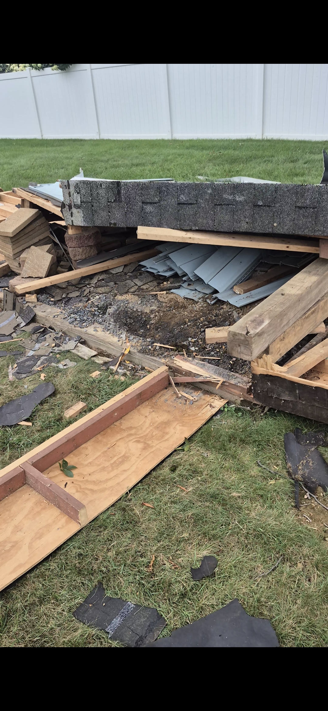 Pile of construction debris in Macungie, PA including shingles, lumber, and cinder blocks before removal